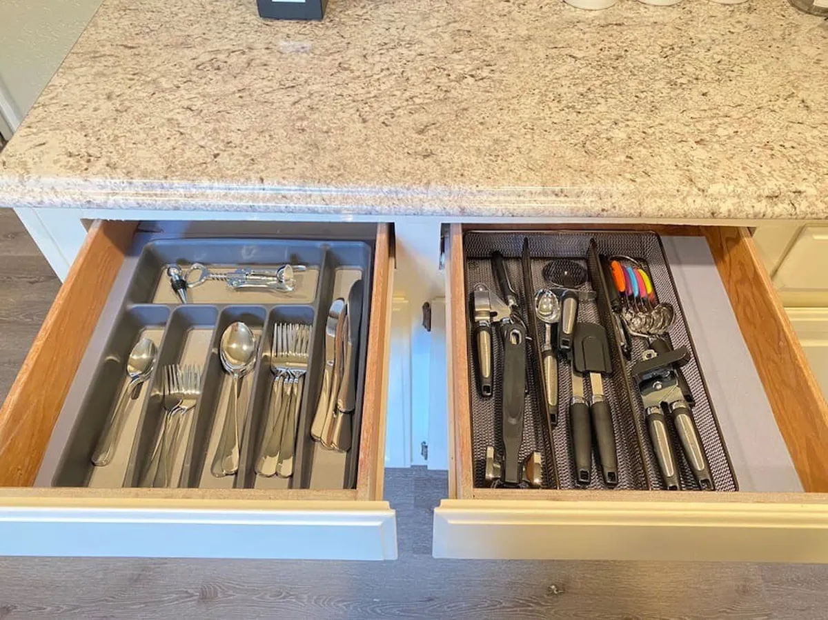 An organized kitchen drawer filled with cutlery and utensils, showcasing the availability of full cookware and efficient organization for meal preparation. The view is practical and inviting, focusing on the hands-on tools for cooking.